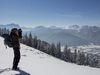 Ein Ranger blickt durch ein Fernglas auf die winterliche Landschaft im Naturpark