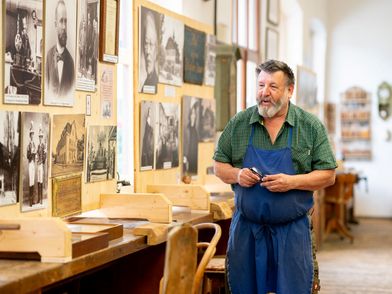 Florian Lang steht in der Ausstellung und erzählt stolz über die Holzschnitzkunst seit 1775.