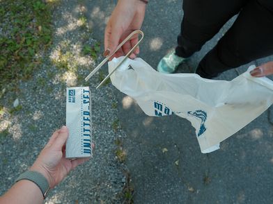 Bild, das Mülltüte und Zange zeigt