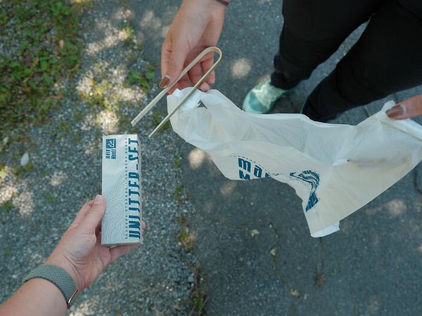 Bild, das Mülltüte und Zange zeigt