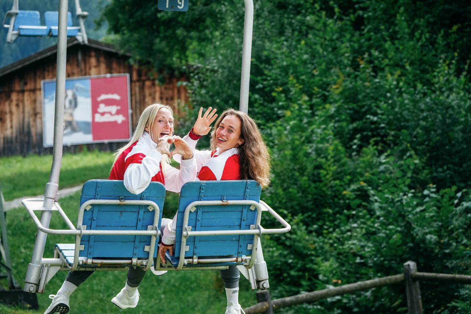 Zwei Vfb Stuttgart Fußballerin sitzen im Sesselift am Hörnle und winken in Richtung Kamera. 