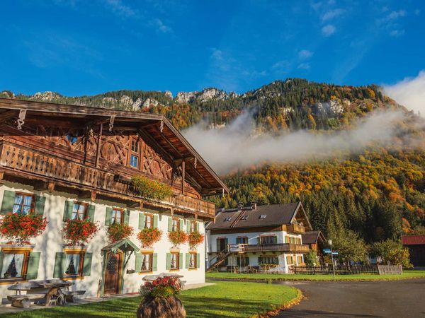 Ein Haus mit Blick auf die Berge mit herbstlicher Stimmung ist zusehen.