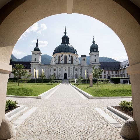 Die barocke Basilika des Kloster Ettal fotografiert durch den gegenüberliegenden Torbogen.