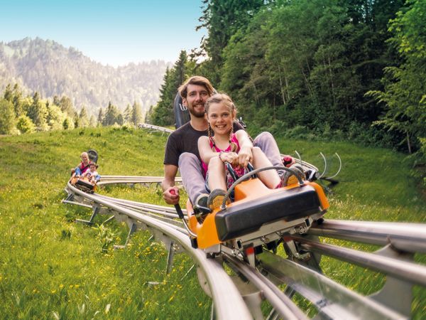 Zwei Personen fahren auf dem Alpine Coaster am Kolbensattel