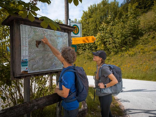 Wanderer vor einer Übersichtstafel